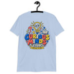 Male teacher wearing a white Curious Minds Club Teacher T-Shirt in an elementary classroom