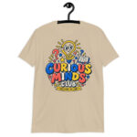 Male teacher wearing a white Curious Minds Club Teacher T-Shirt in an elementary classroom
